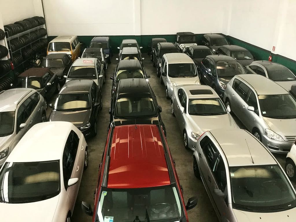 Il magazzino coperto di El Hajj Auto Export a Travagliato, con decine di auto usate pronte alla vendita